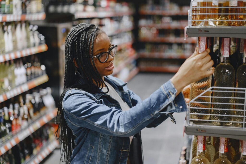 Customer peruses bottles at a liquor store where wholesalers likely helped distillers distribute product.